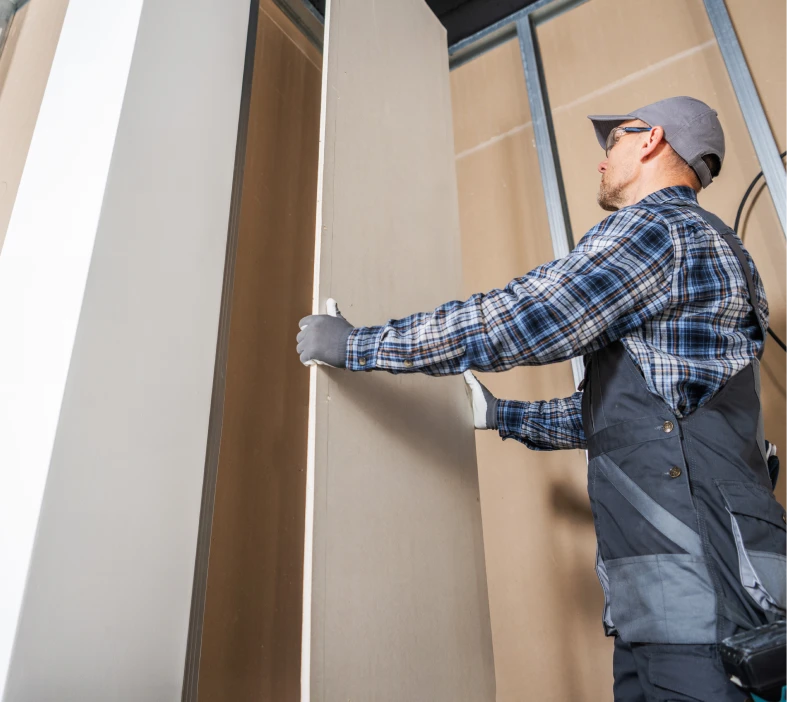 Worker installing drywall panel