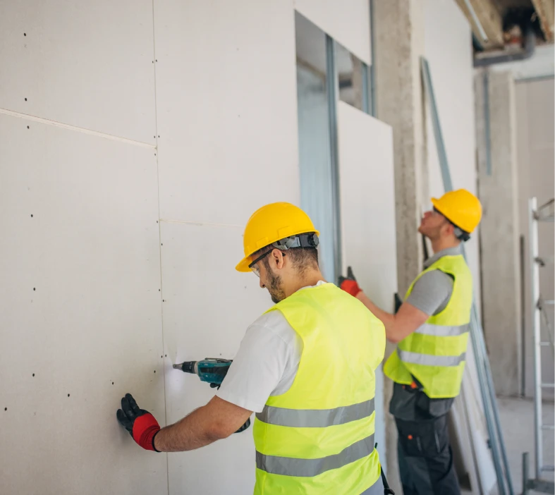 Construction workers installing drywall